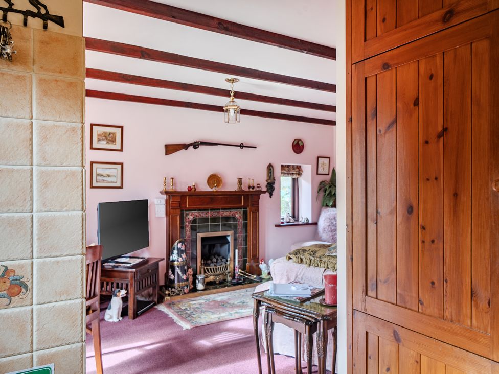A living room with a fireplace and furniture at Converted Stone Barn -20 Acres - Farm Animals! in Corwen