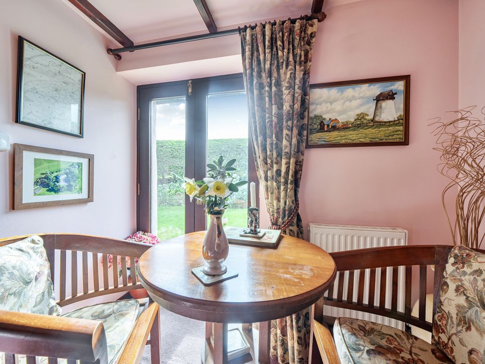 A snug area with a table and chairs at Converted Stone Barn -20 Acres - Farm Animals! in Corwen
