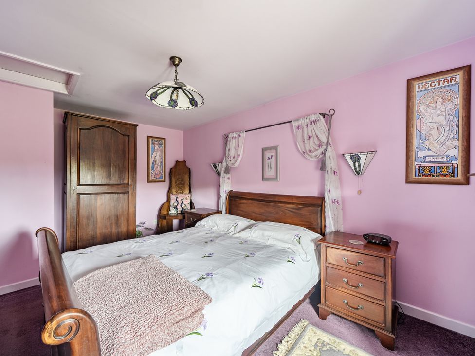 A bedroom with a bed and nightstand at Converted Stone Barn -20 Acres - Farm Animals! in Corwen