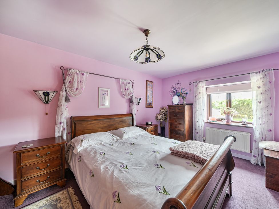 A bedroom with a bed and nightstand at Converted Stone Barn -20 Acres - Farm Animals! in Corwen