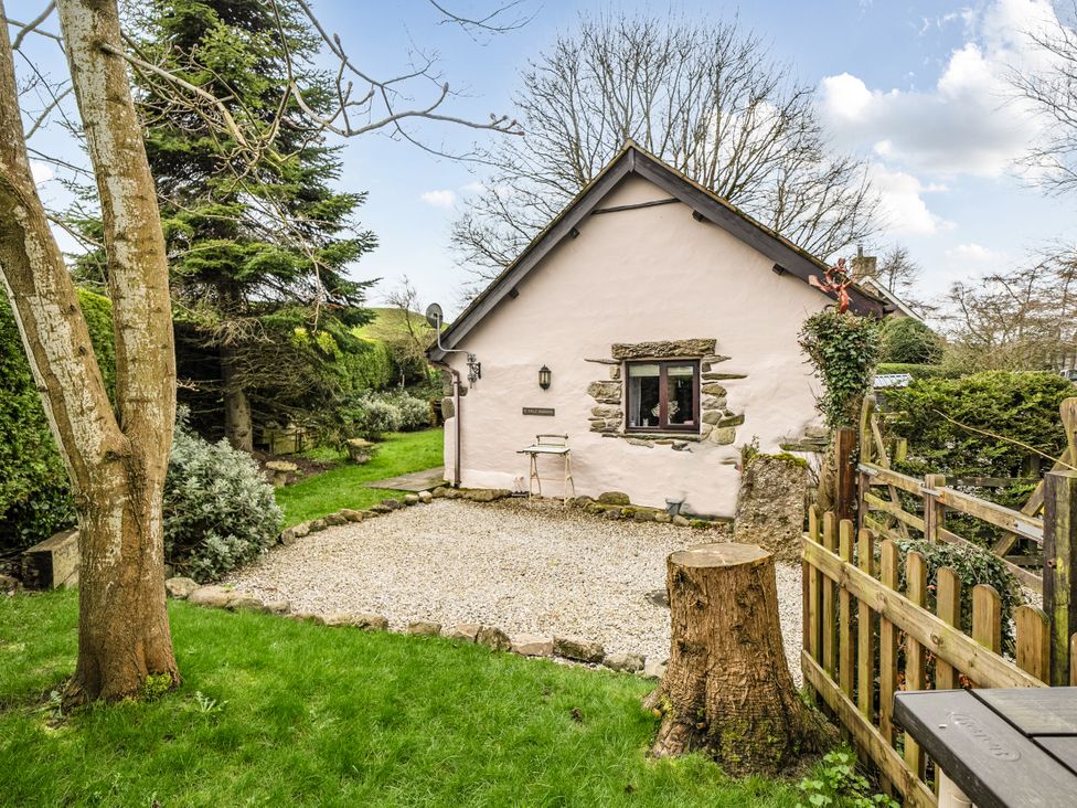A house with gravel path and trees at Converted Stone Barn -20 Acres - Farm Animals! in Corwen