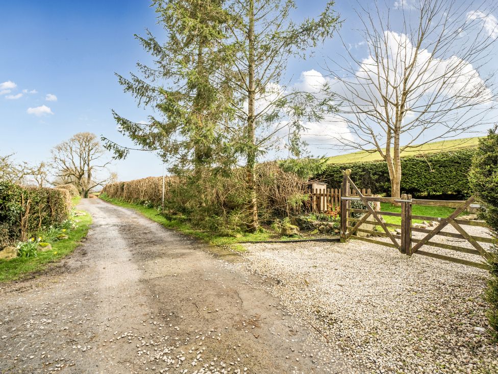 A gravel path leading to a gate with trees alongside at Converted Stone Barn -20 Acres - Farm Animals! Corwen