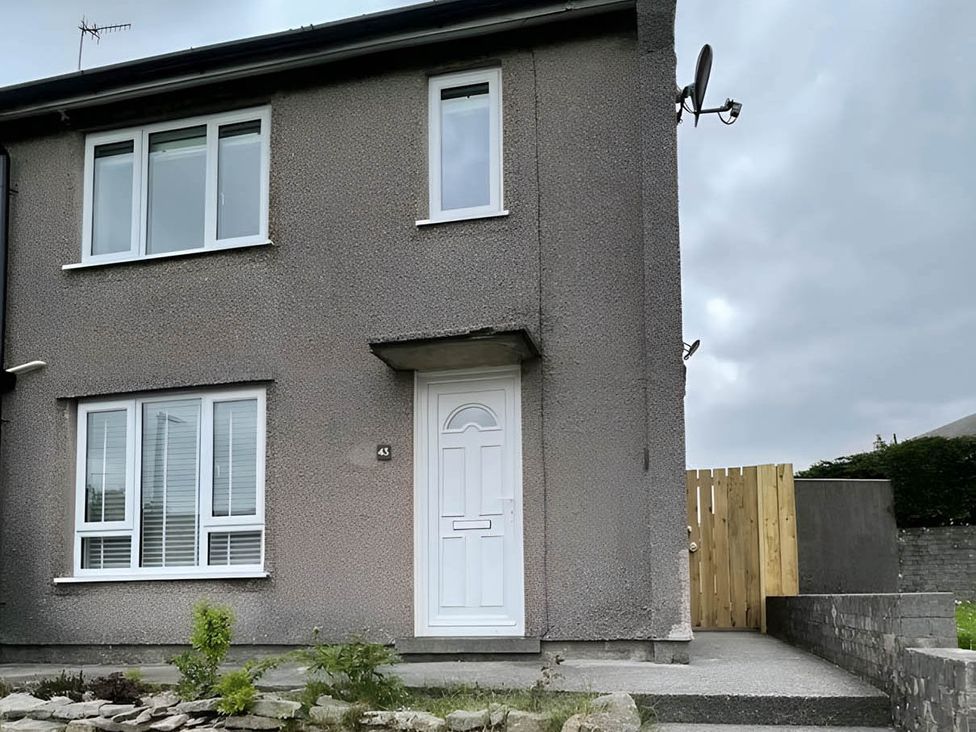 A house with a white door and windows at 2 Bed House - Sleeps 4 - Garden - Parking - Wifi in Kendal