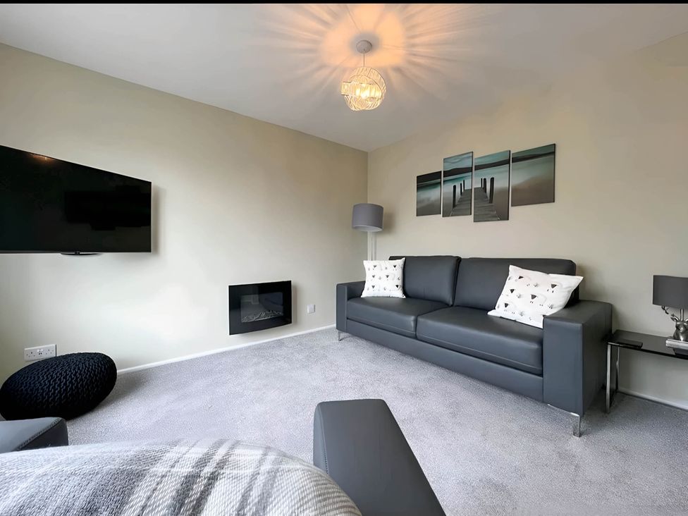 A living room with a sofa, television, and lamp at 2 Bed House - Sleeps 4 - Garden - Parking - Wifi, Kendal
