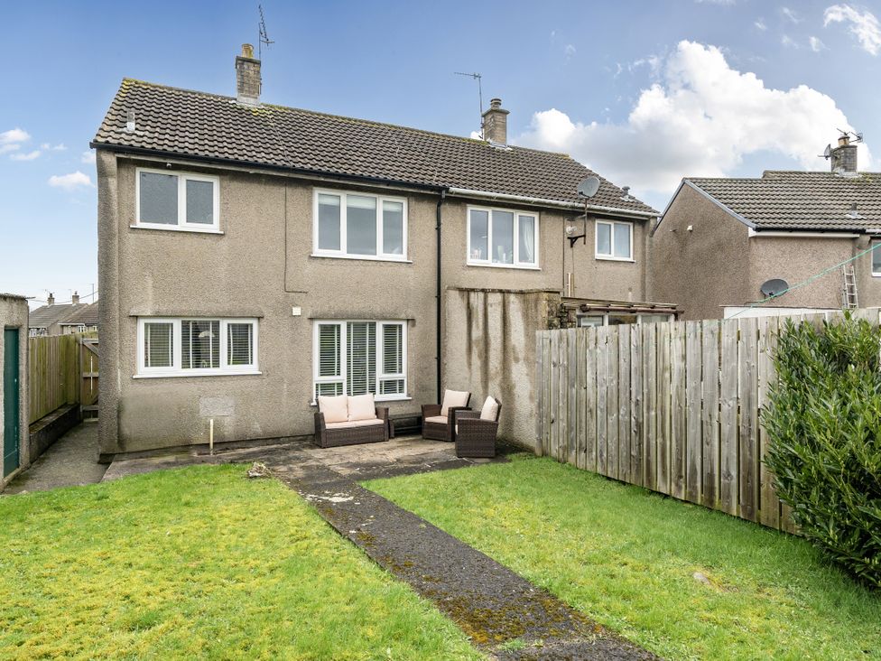 A garden with a house and seating area at 2 Bed House - Sleeps 4 - Garden - Parking - Wifi, Kendal