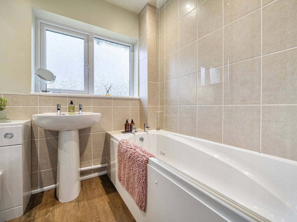A bathroom with a bathtub and sink at 2 Bed House - Sleeps 4 - Garden - Parking - Wifi in Kendal