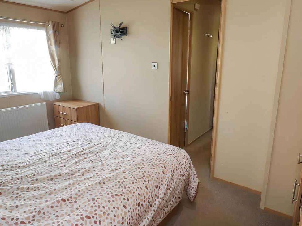 A bedroom with a bed and nightstand at CaravanSleeps6-FreeParking-QuietRetreat-Nature in Paignton