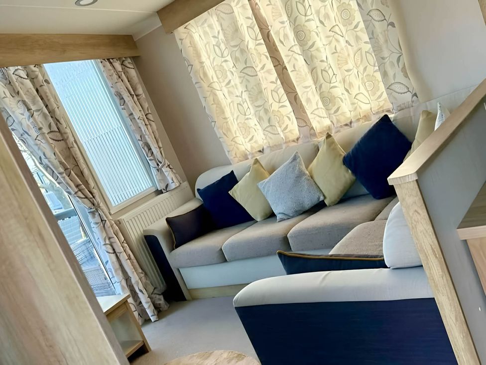A living room with a sofa and cushions at 293 Static caravan Beverley Bay Paignton