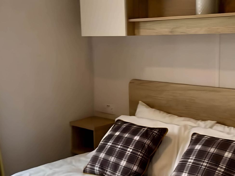 A bedroom with a bed and pillows at 293 Static caravan Beverley Bay Paignton