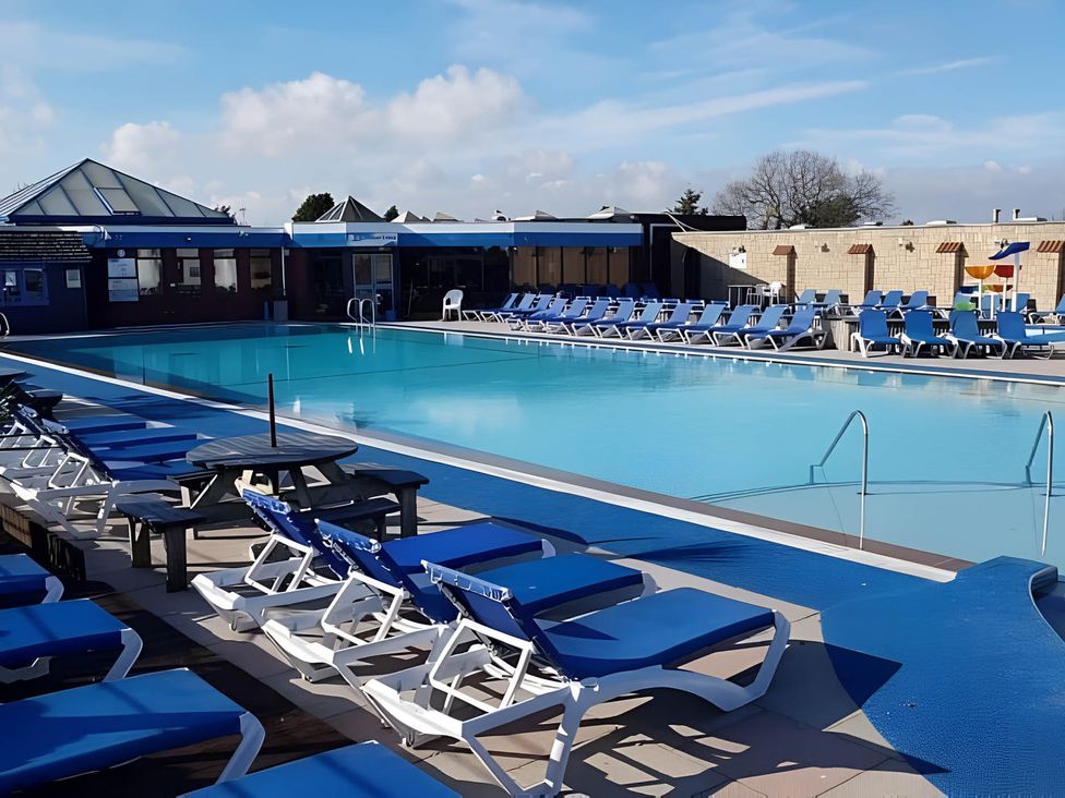 An outdoor pool area with sun loungers and a swimming pool at 293 Static caravan Beverley Bay Paignton
