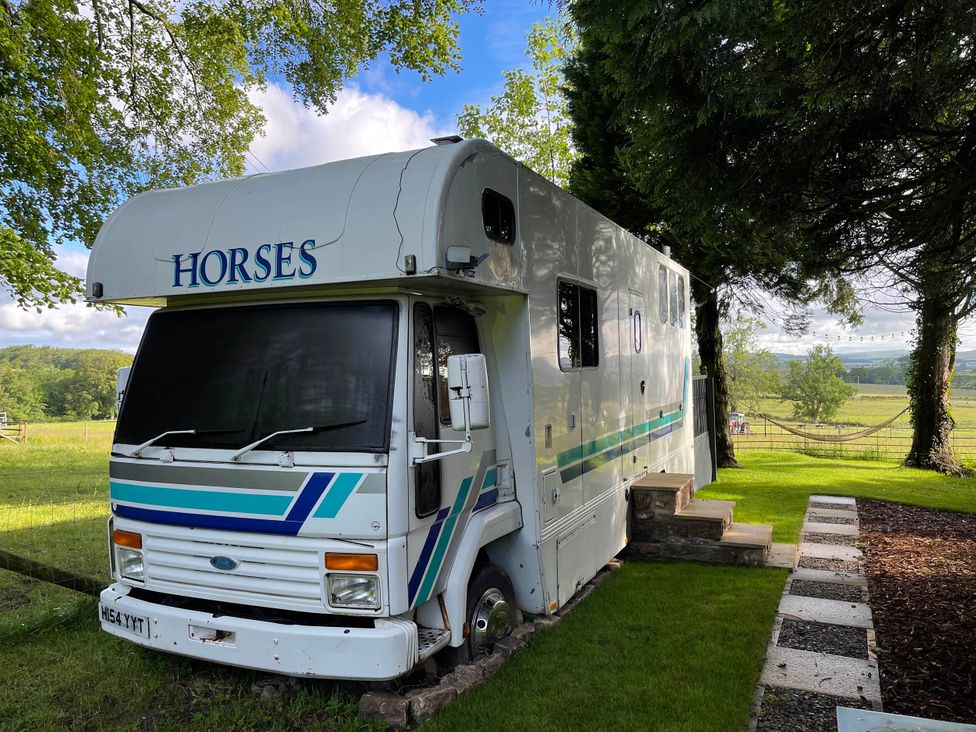 A horsebox parked on grass with steps leading up to it at Dobbin the horse box in The Lake District Cockermouth