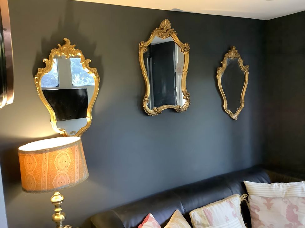 A living room with mirrors and lamp at Dobbin the horse box in The Lake District Cockermouth