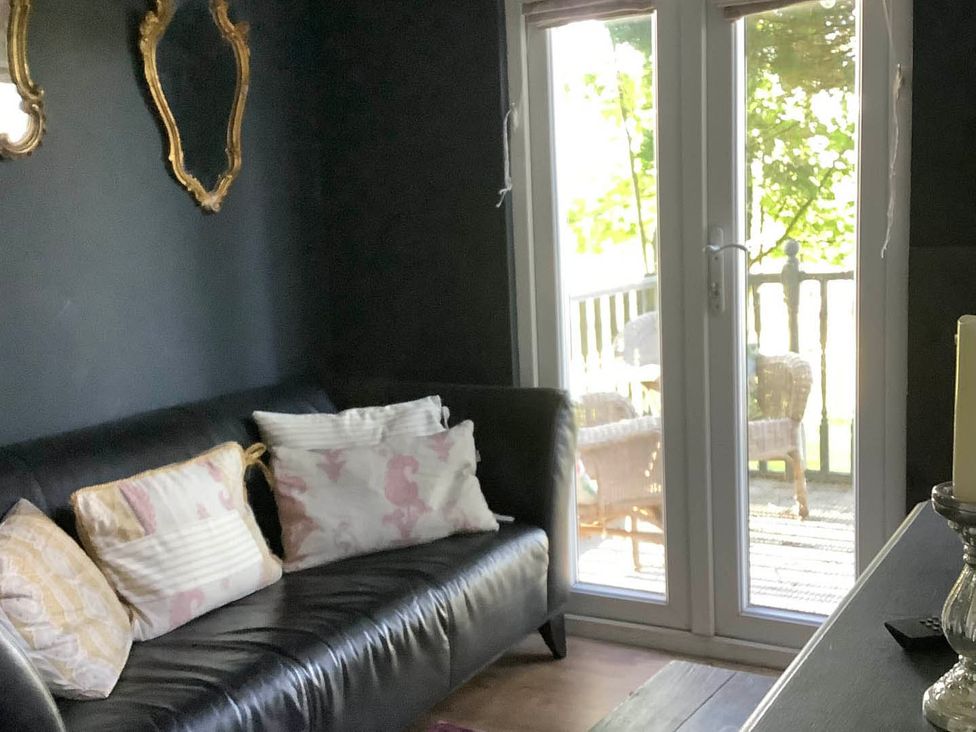 A living room with a sofa and cushions at Dobbin the horse box in The Lake District