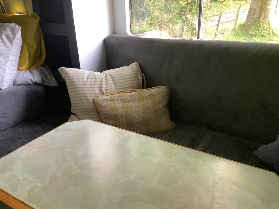 A living room with a couch and pillows at Dobbin the horse box in The Lake District