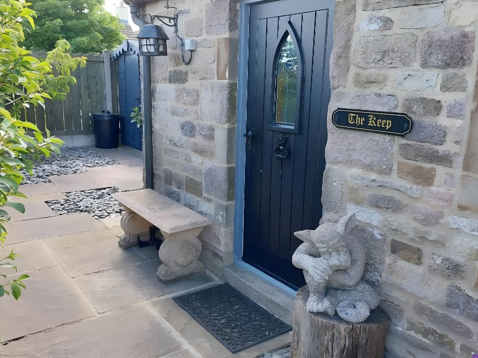 An outdoor entrance with a door and a stone bench at The Keep in Buxton