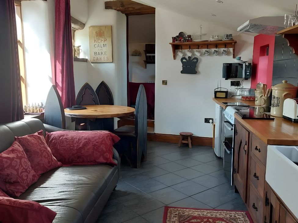 A kitchen with a table and chairs, sofa, and appliances at 1 Bed Cottage - Sleeps 3 - Garden - Parking - Wifi in Buxton