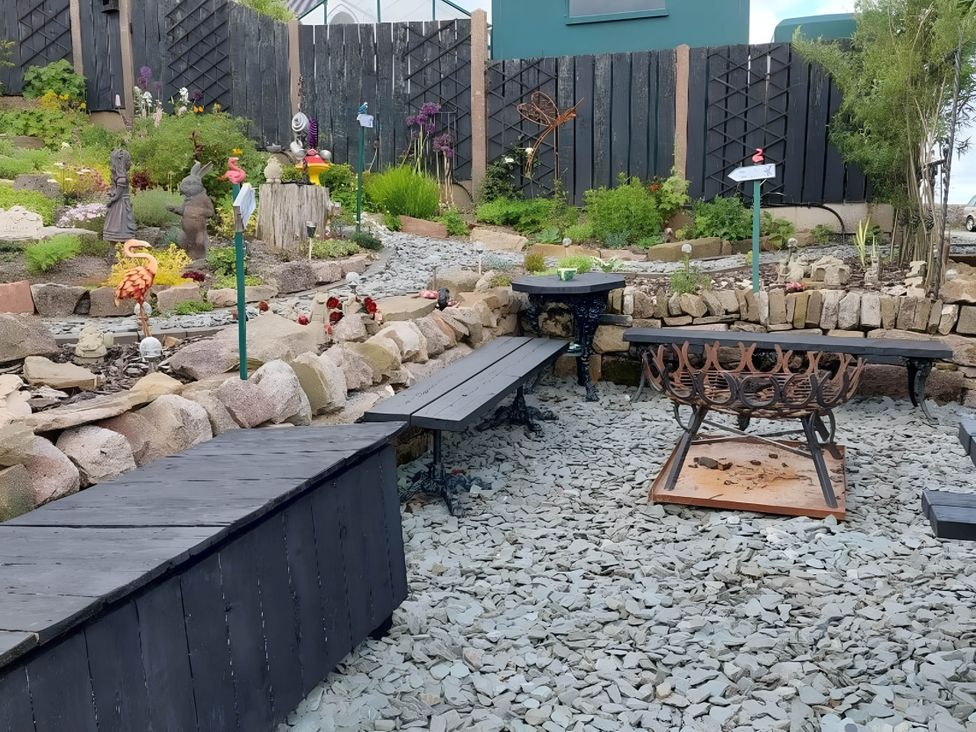 A garden with benches, a fire pit, and decorative statues at 1 Bed Cottage - Sleeps 3 - Garden - Parking - Wifi, Buxton