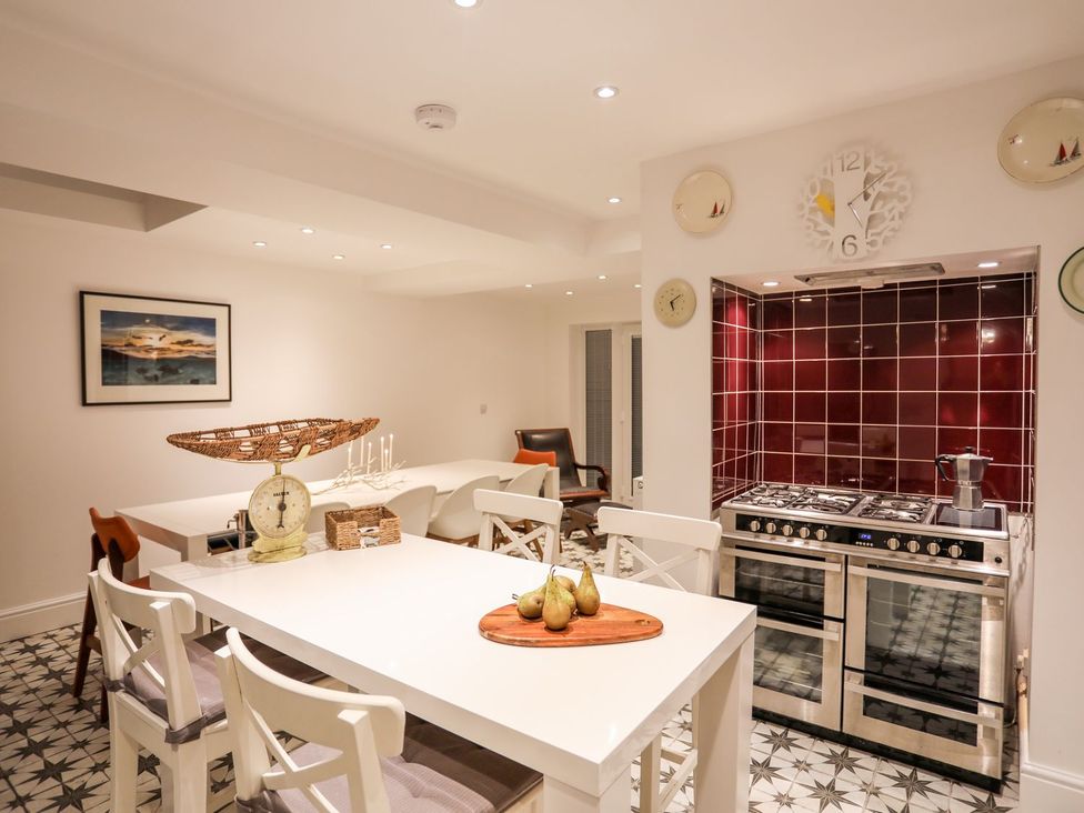 A kitchen with a table and chairs at Rhiwlas in Rhosneigr