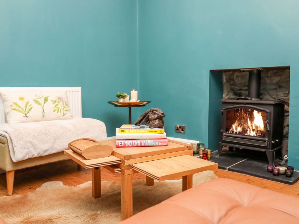 A living room with a fireplace and coffee table at Rhiwlas in Rhosneigr