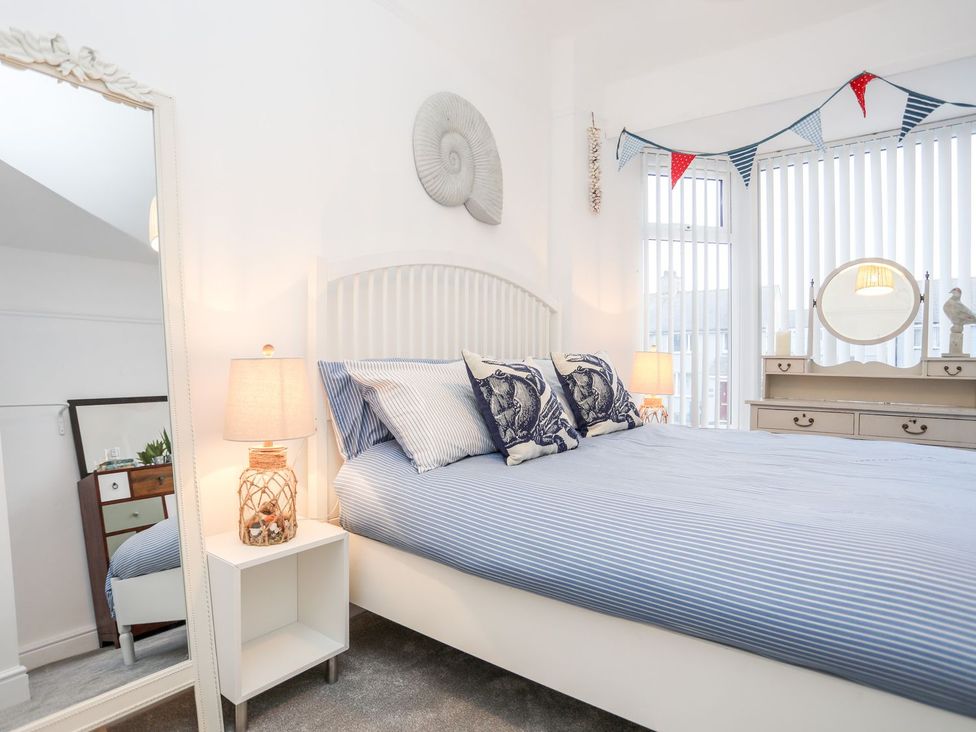 A bedroom with a bed and dresser at Rhiwlas in Rhosneigr