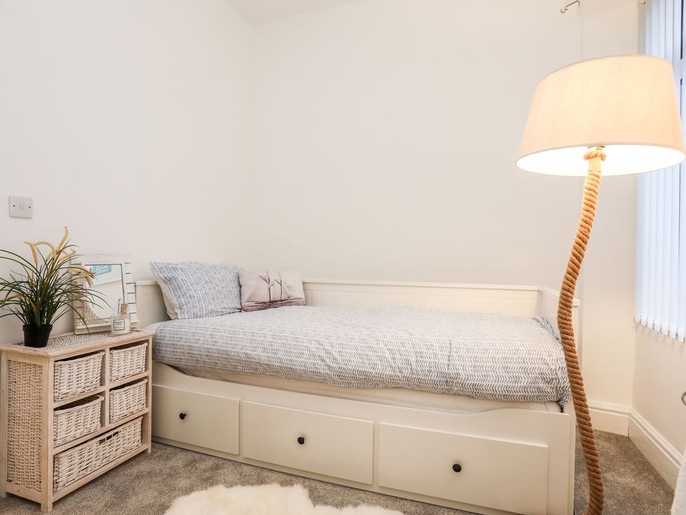 A bedroom with a bed and lamp at Rhiwlas in Rhosneigr