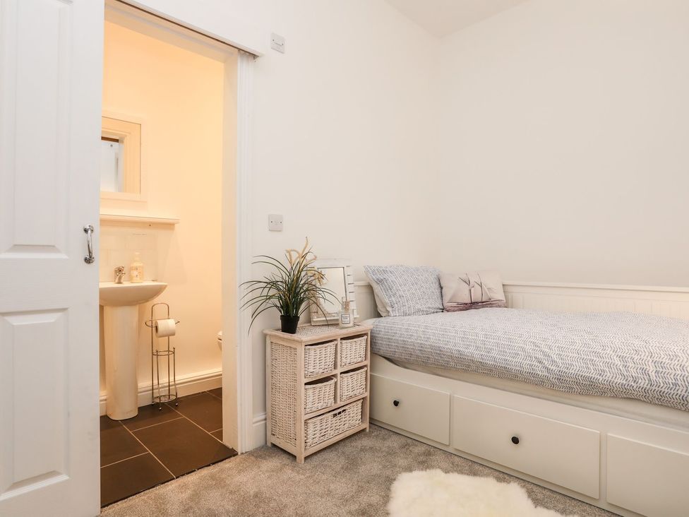 A bedroom with a bed and a wash basin at Rhiwlas in Rhosneigr
