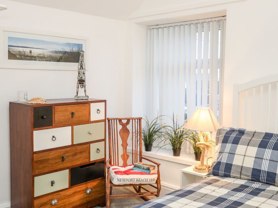 A bedroom with a bed and drawers at Rhiwlas in Rhosneigr