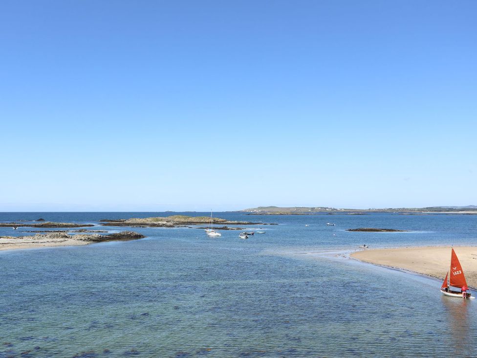 A beach with boats and islands at Rhiwlas in Rhosneigr