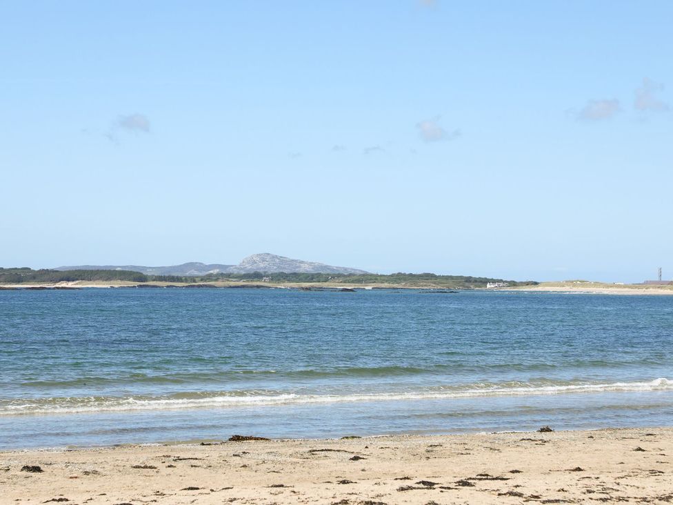 A beach with sand and water at Rhiwlas in Rhosneigr