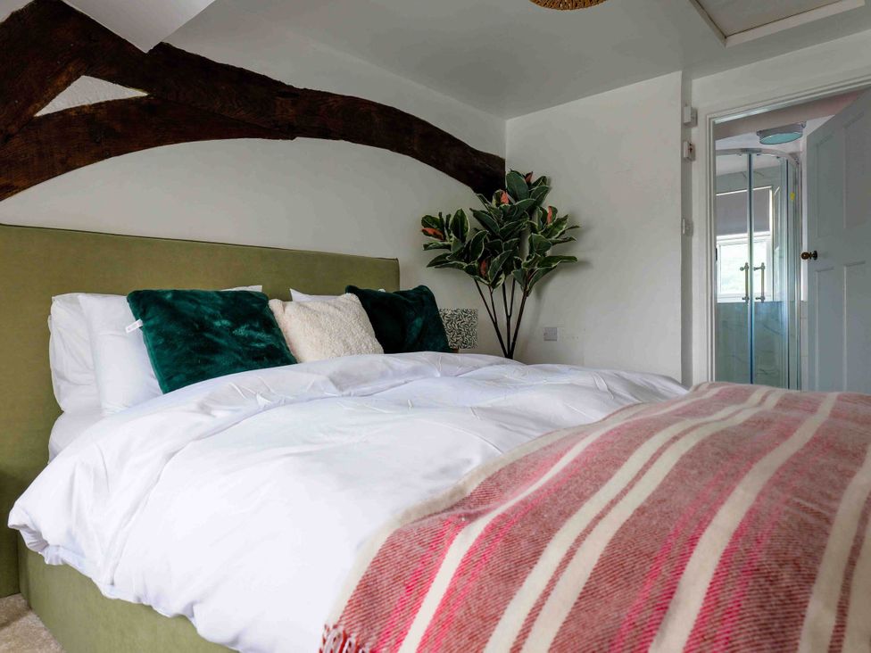 A bedroom with a bed and plant at Cotswolds Cozy Cottage Retreat - pet friendly Finstock