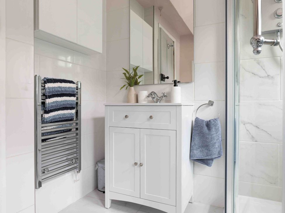 A bathroom with a sink and towel rack at Cotswolds Cozy Cottage Retreat - pet friendly, Finstock