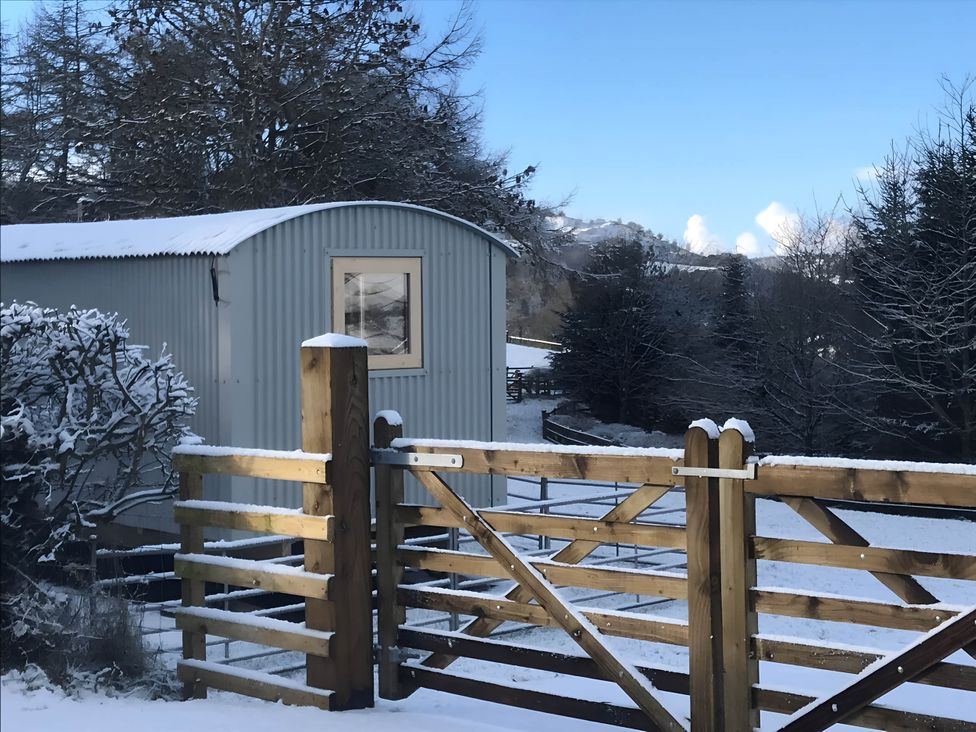 A shed and gate in the snow at The Shepherds Hut at Hafoty Boeth Corwen