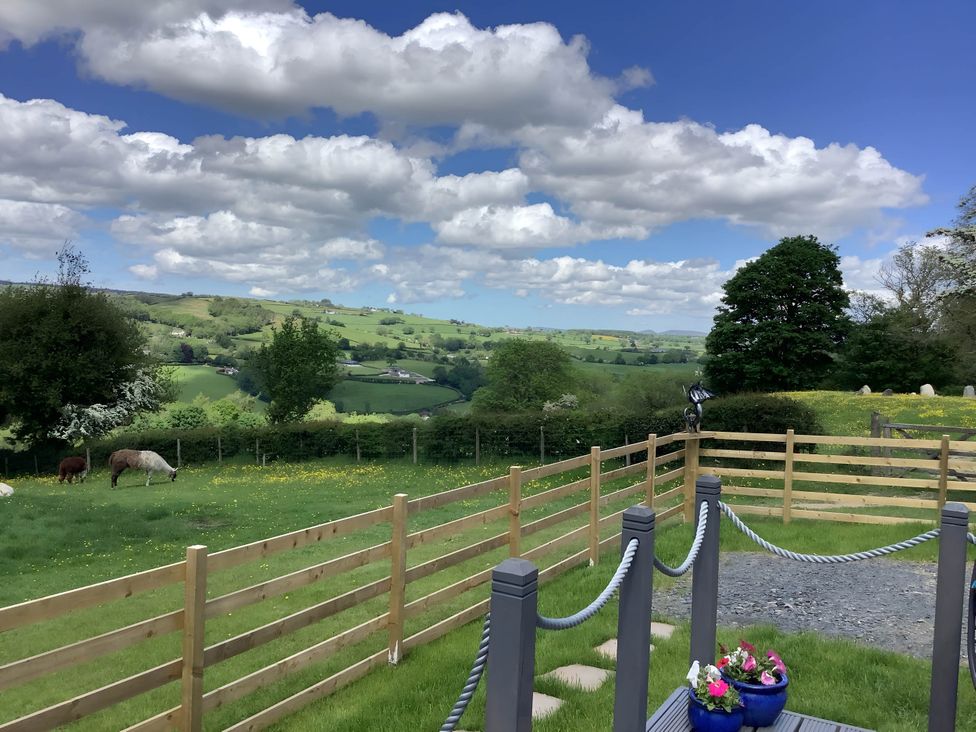 A view of the countryside with grass and a fence at The Shepherds Hut at Hafoty Boeth Corwen