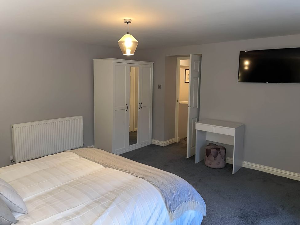 A bedroom with a bed and a wardrobe at Cosy Apartment above Village Pub