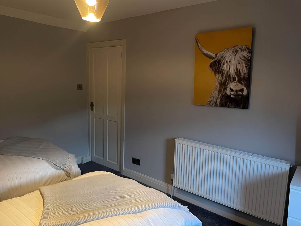 A bedroom with two beds and a painting on the wall at Cosy Apartment above Village Pub