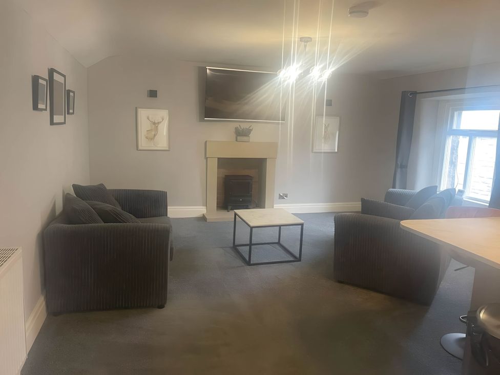 A living room with furniture and a television at Cosy Apartment above Village Pub