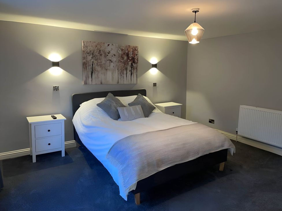 A bedroom with a bed and bedside tables at Cosy Apartment above Village Pub
