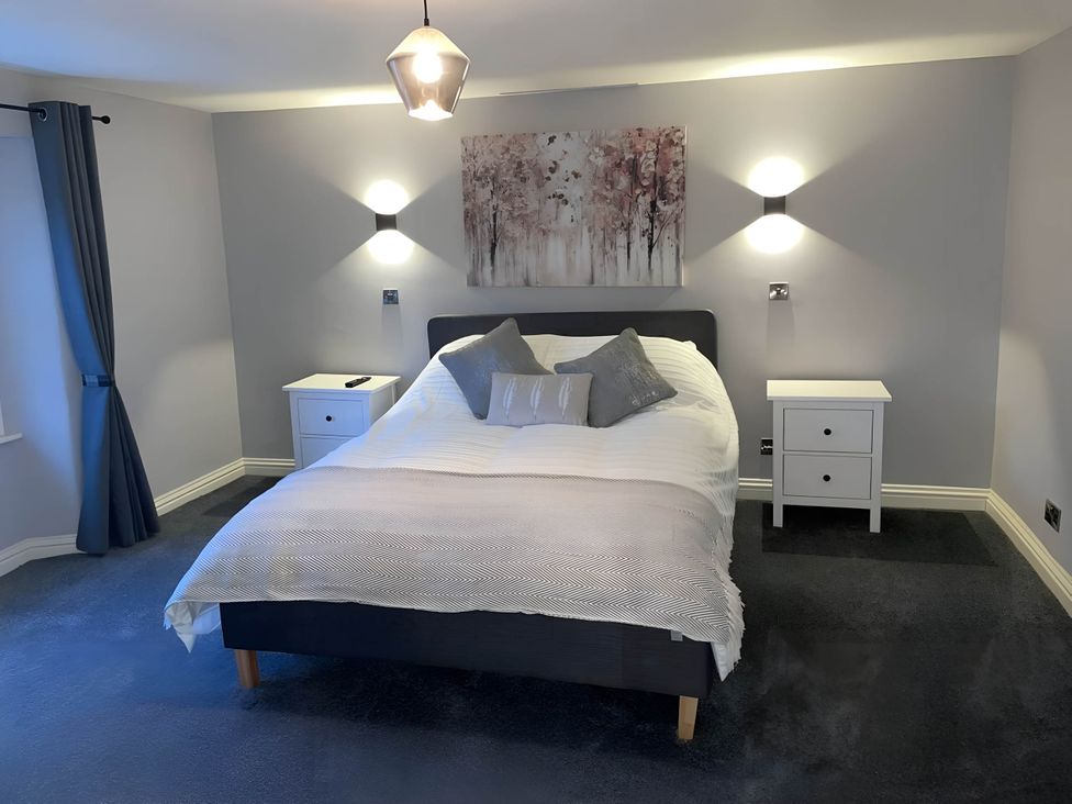 A bedroom with a bed and nightstands at Cosy Apartment above Village Pub