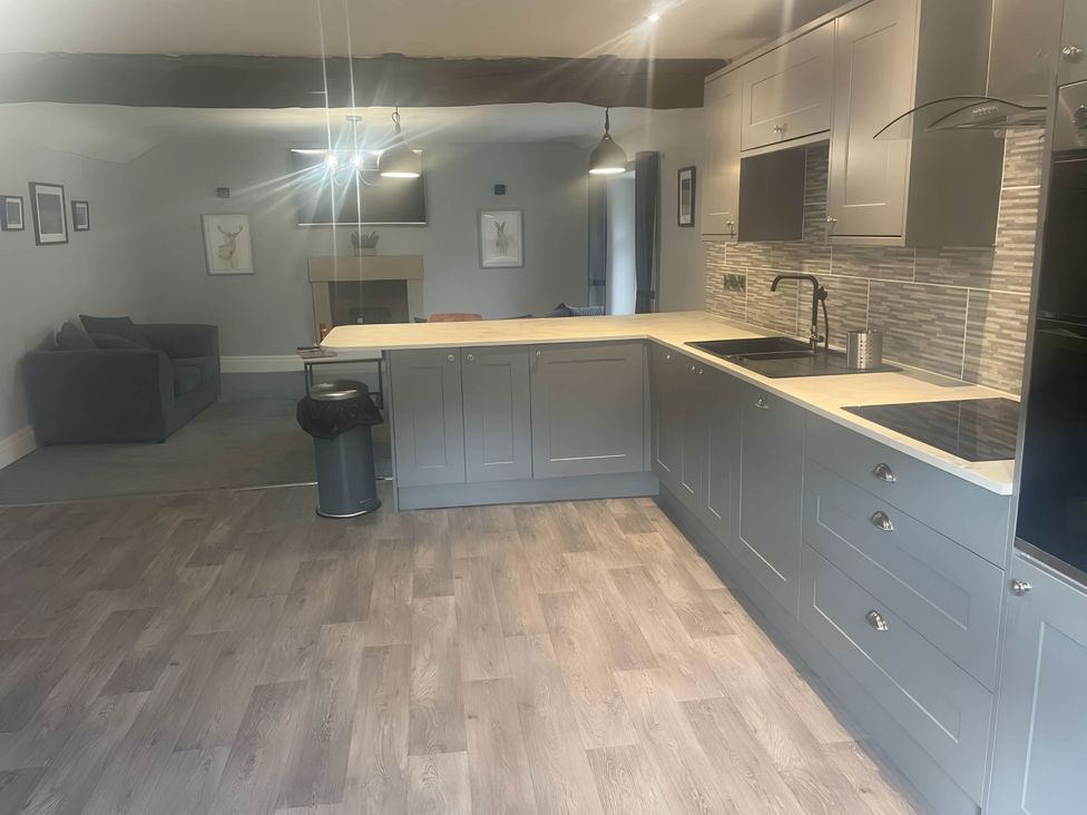 A kitchen with a counter and sofa at Cosy Apartment above Village Pub