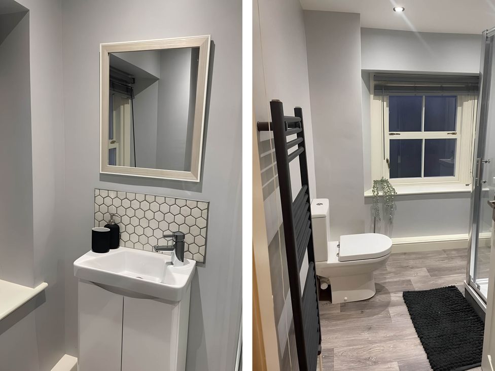 A bathroom with a sink, toilet, and shower at Cosy Apartment above Village Pub