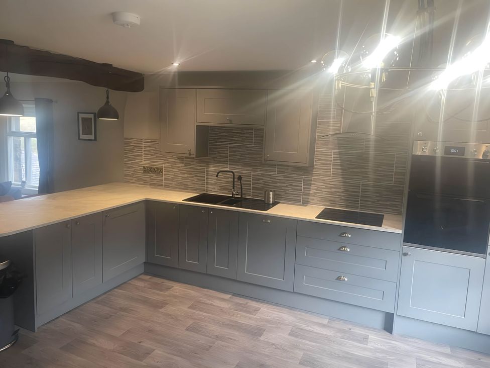 A kitchen with a sink, stove, and cabinets at Cosy Apartment above Village Pub