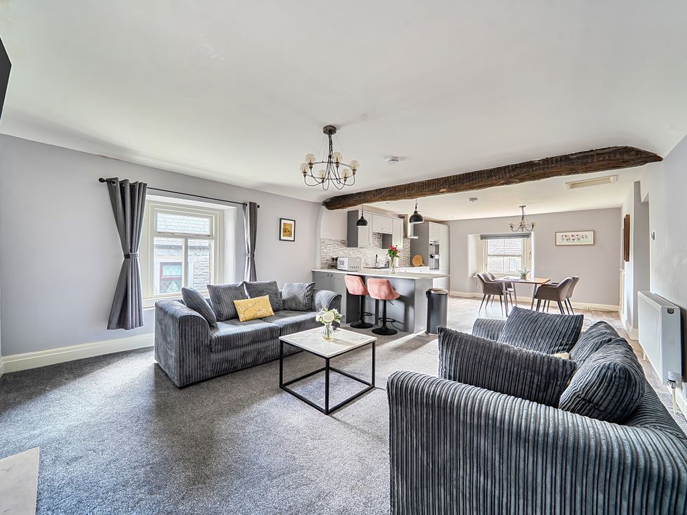A living room with a sofa and coffee table at Cosy Apartment above Village Pub in Taddington