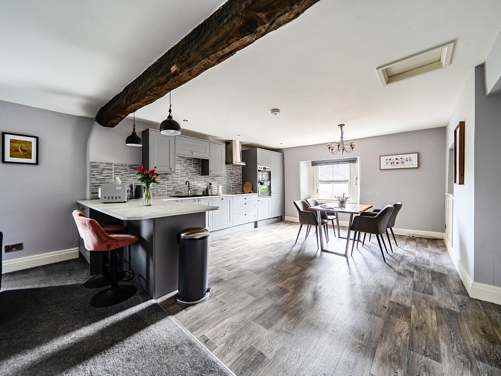 A kitchen with a dining area and appliances at Cosy Apartment above Village Pub in Taddington