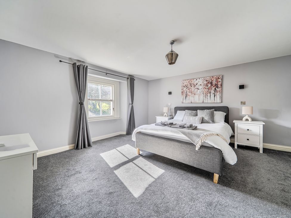 A bedroom with a bed and nightstands at Cosy Apartment above Village Pub in Taddington