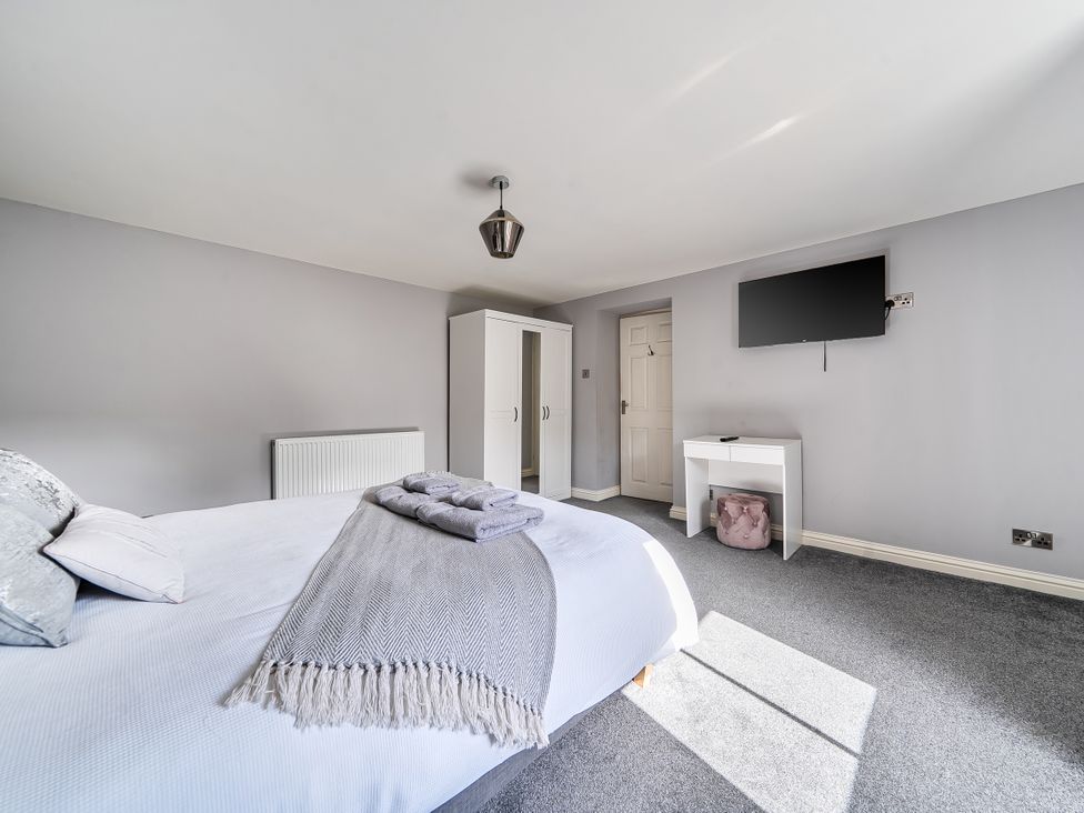 A bedroom with a bed and wardrobe at Cosy Apartment above Village Pub Taddington