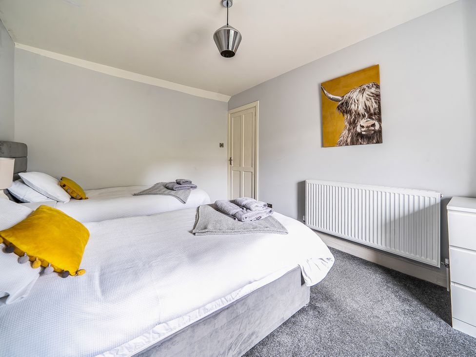 A bedroom with two beds and a painting at Cosy Apartment above Village Pub Taddington