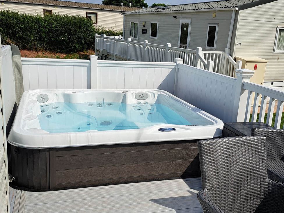 A hot tub on a deck at Tranquil Lodge Retreat in Paignton