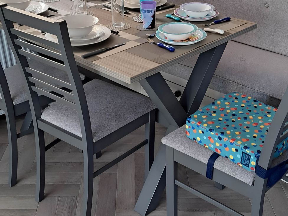 A dining table set with plates and glasses at Tranquil Lodge Retreat in Paignton