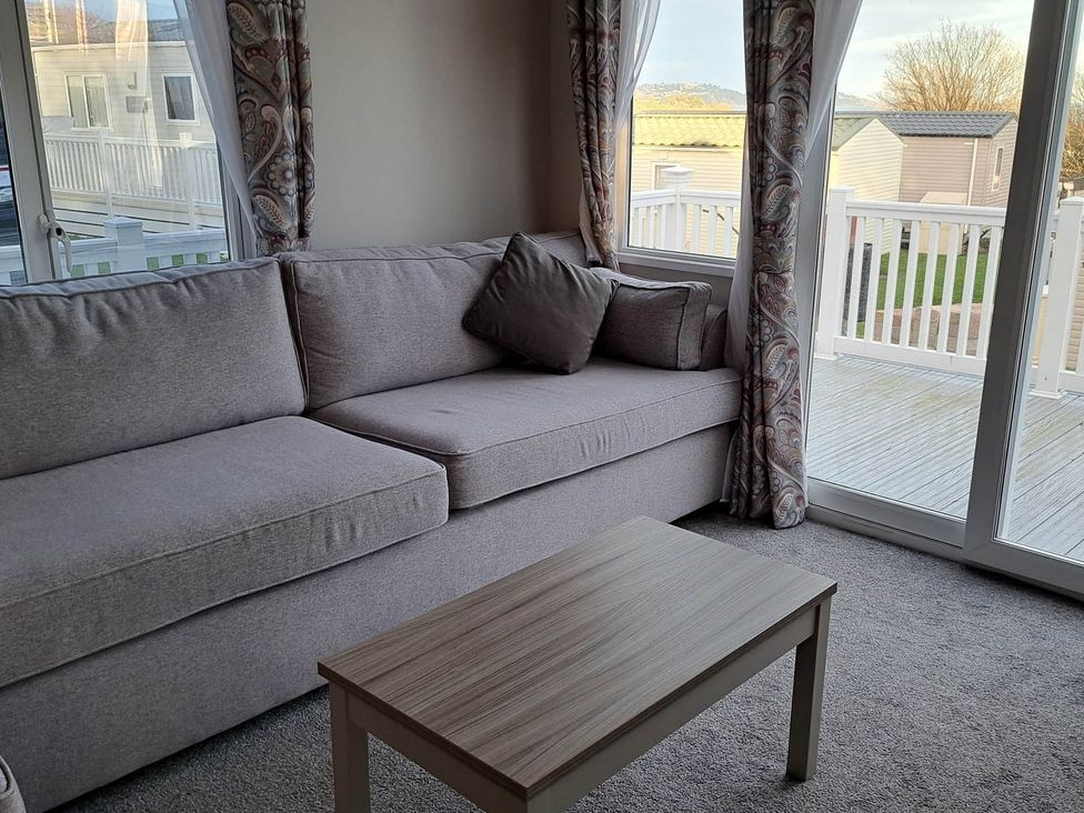 A living room with a sofa and coffee table at Tranquil Lodge Retreat in Paignton