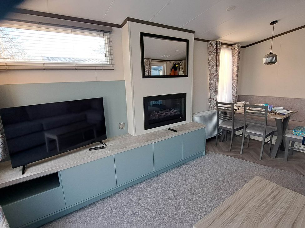 A living room with a television and fireplace at Tranquil Lodge Retreat in Paignton